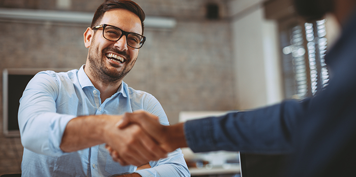 Smiling man shaking hands with some in a business